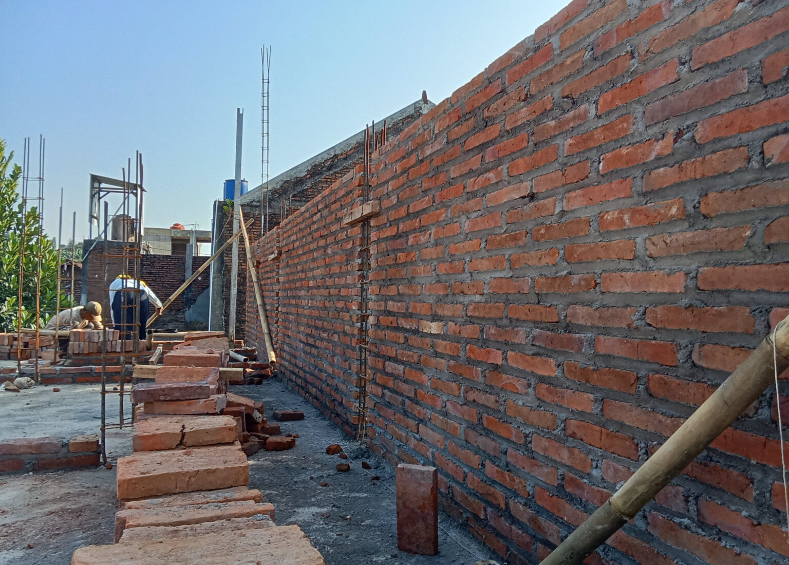 Operario de Grupo Ortega rematando un muro de ladrillo visto.